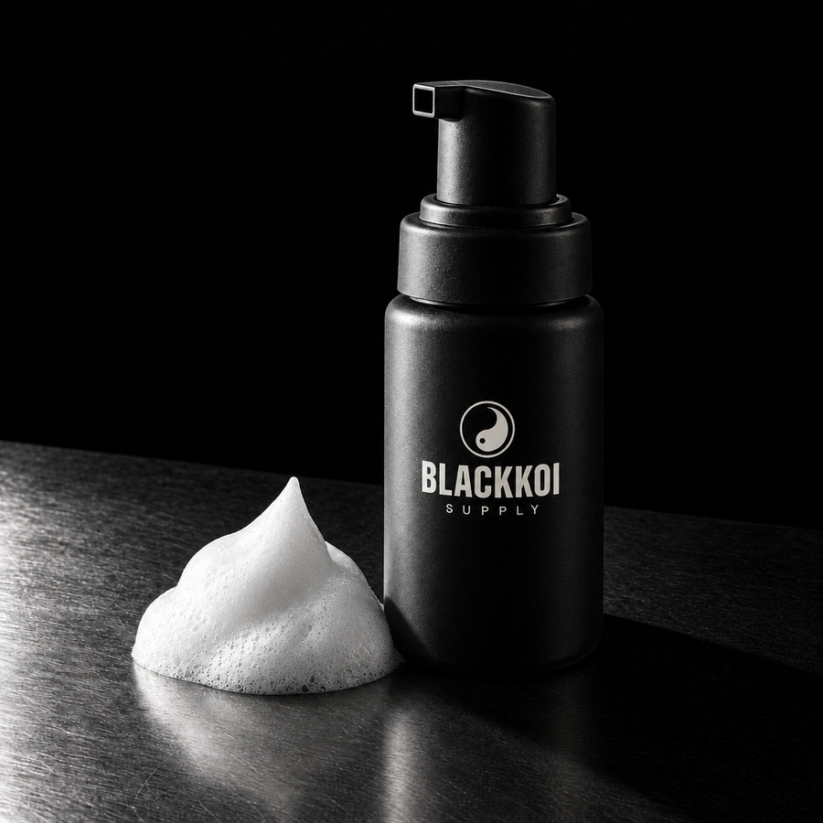 Aftercare foam cleanser, 60 ml pump bottle in BlackKoi Supply packaging, with a mound of foam